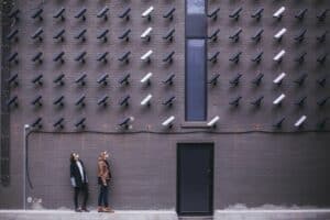 proactive-cybersecurity Two women looking up at a wall of security cameras on a buildings exterior