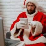 An image of a hacker using a Santa's costume while stealing business information