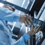 Data Backup An IT technician is installing a hard drive into a server in a data center.