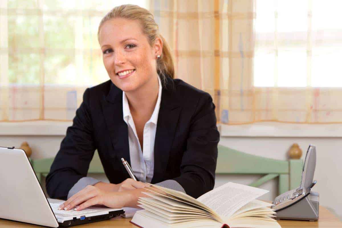 Young Lawyer Smiling While Using Computer to Find Clients Data in the Network