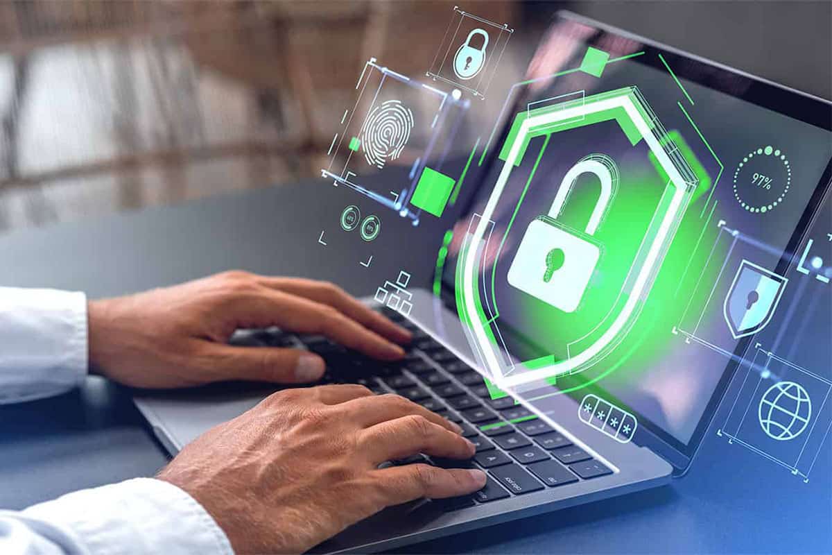 Man ensures San Jose business compliance with cybersecurity on laptop.