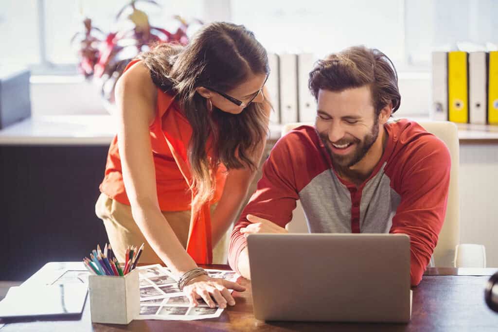 Two business people are working together using a laptop.